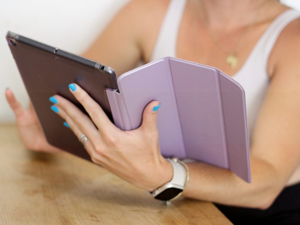 Laura holding a tablet while reviewing a training plan